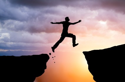 Silhouette of hiking man jumping over the mountains